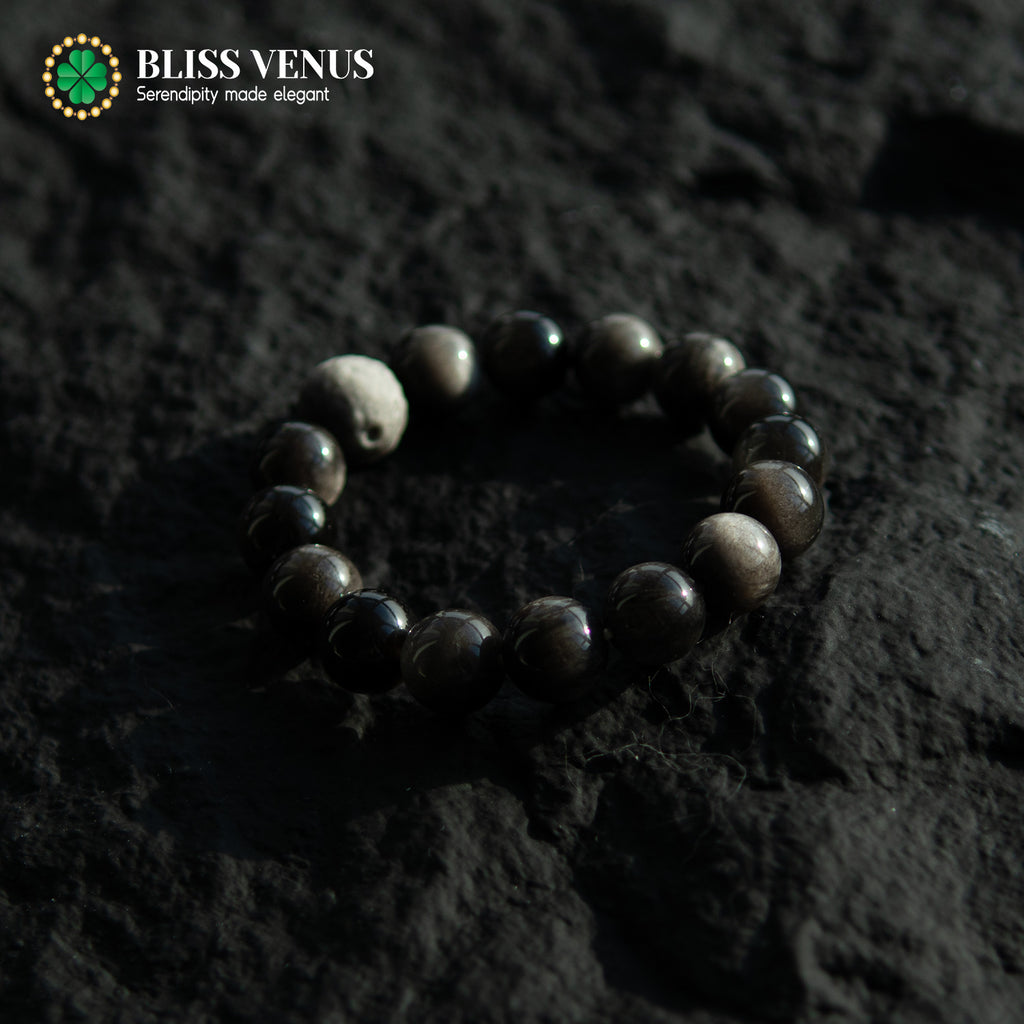 Close-up of black obsidian bracelet showing natural silver and black stone texture and luster