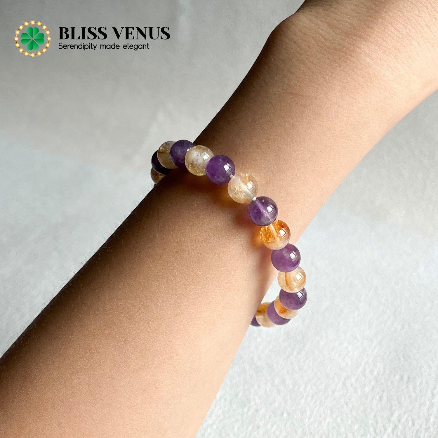 Close-up of purple and yellow crystal bracelet showing natural amethyst and citrine gemstone colors