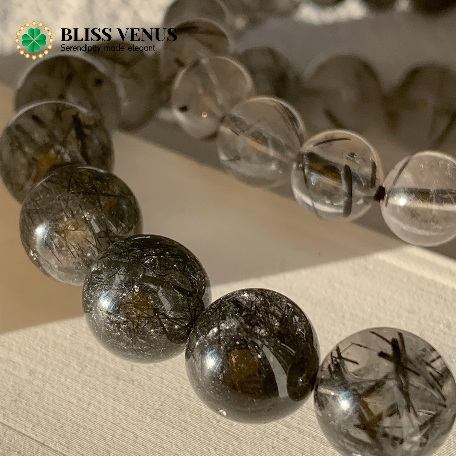 Side angle of black hair crystal bracelet showing bead arrangement and root chakra stone