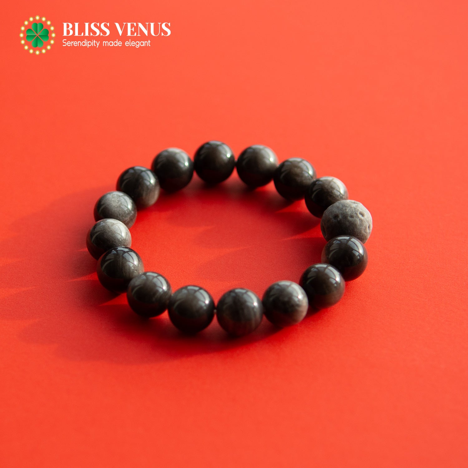 Side angle of obsidian bracelet showing bead arrangement and root chakra energy stone